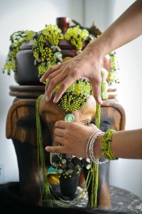 A Babalawo -a kind of priest of the Yoruba religion- adjusts the ornaments to deity Orula in Caracas on September 12, 2010. AFP PHOTO / Miguel GUTIERREZ